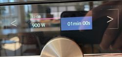 A black surface, black display background and white text. The selection display is split into two halves. The left side shows the power input. It has a black background with a red top border. On the right side, I adjust the timer. It shows this side with a blue background.
